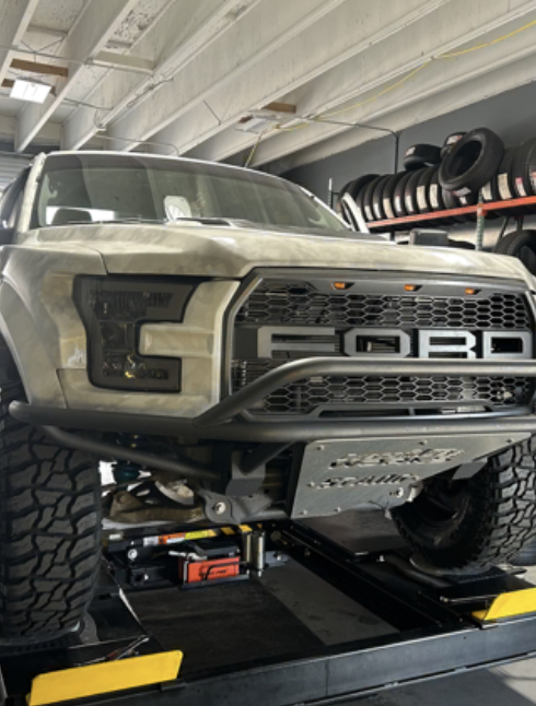 Ford Raptor on the lift with off-road tires
