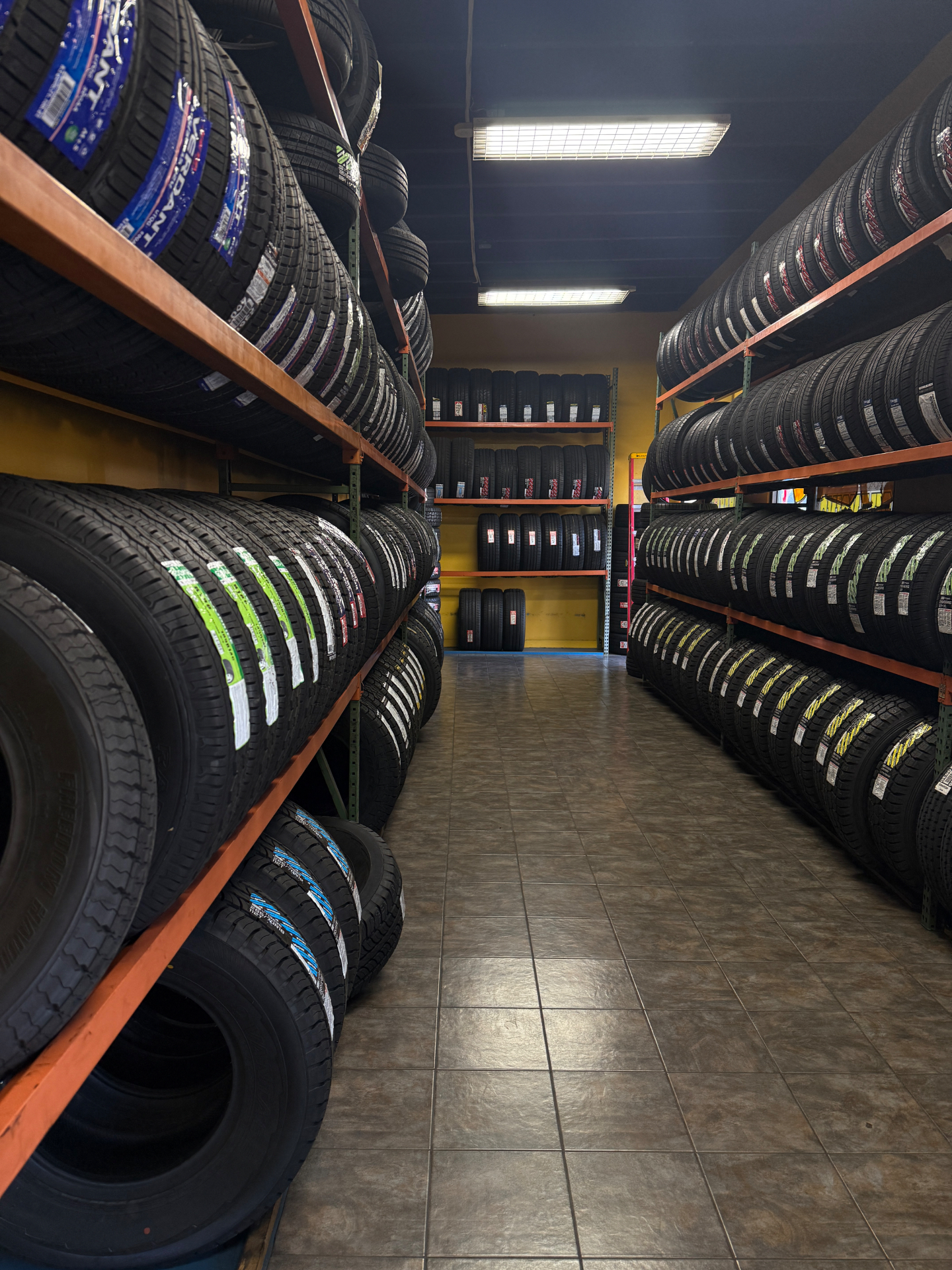 Inside the Tires 4 Less warehouse with stocked tire racks